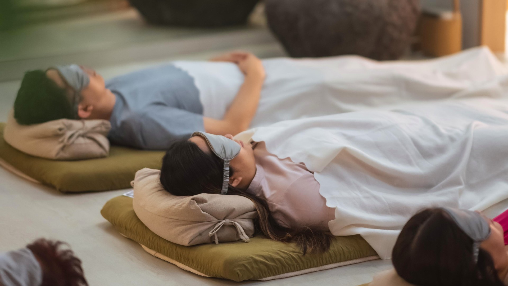 Participants settling onto mats before a Sound Bath